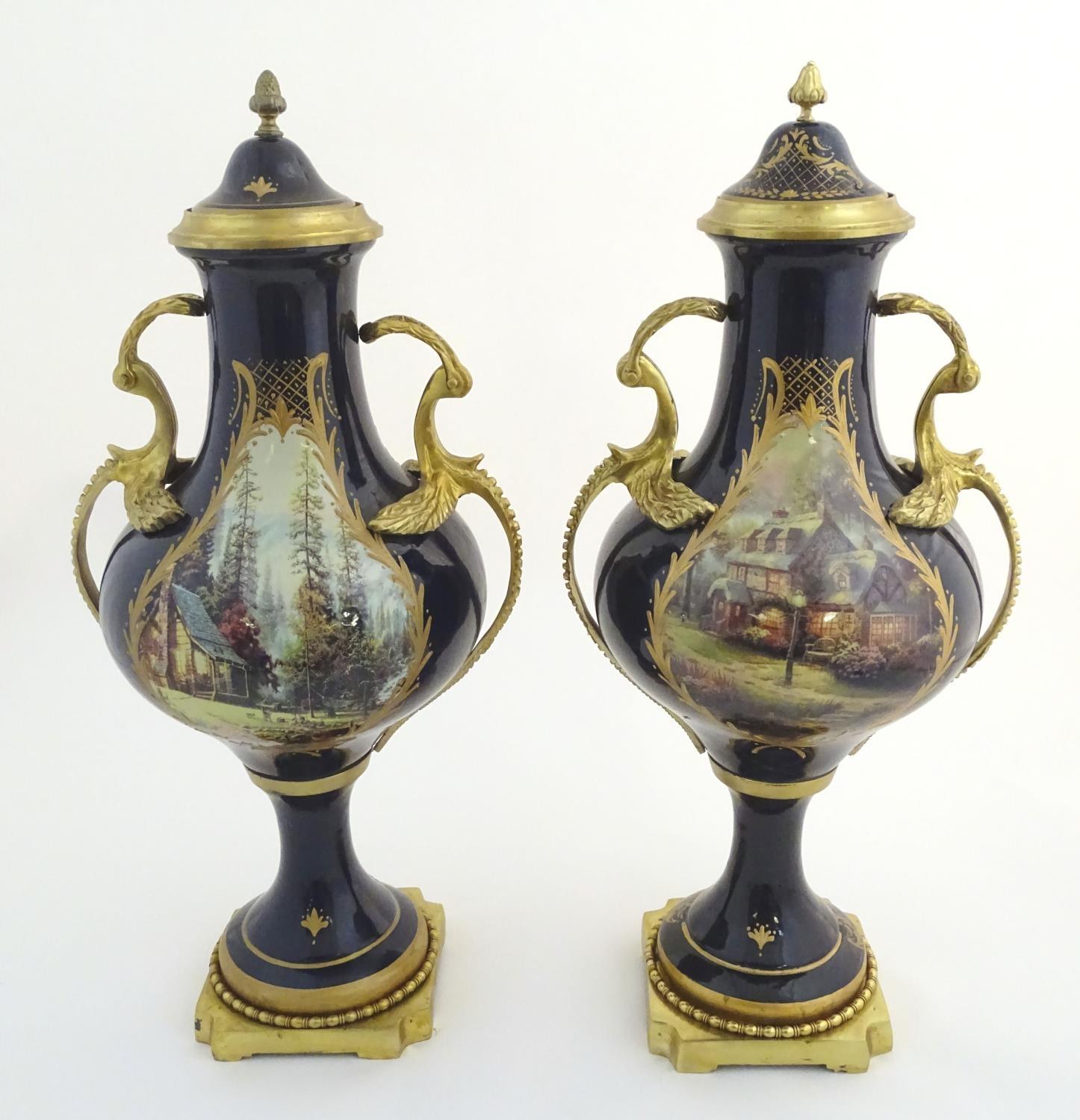 A matched pair of Sevres style lidded urn garnitures on mounted bases, with cobalt blue