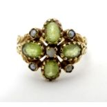 A 9ct gold ring set with peridot and seed pearl. Ring size approx size O. Please Note - we do not