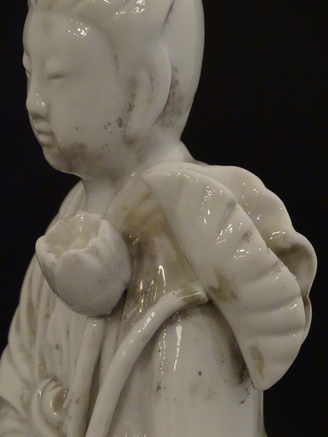 A Chinese blanc de chine figure of Guanyin holding flowers, raised on a base of lotus flowers and - Image 9 of 9