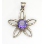 A Mexican silver pendant of floral form set with central amethyst. 1 1/2" long Please Note - we do