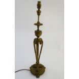 Lighting: an Edwardian gilt brass table lamp, the urn dish and column supported by three scrolling