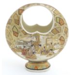 A Japanese satsuma moon basket vase with hand painted decoration depicting figures seated around