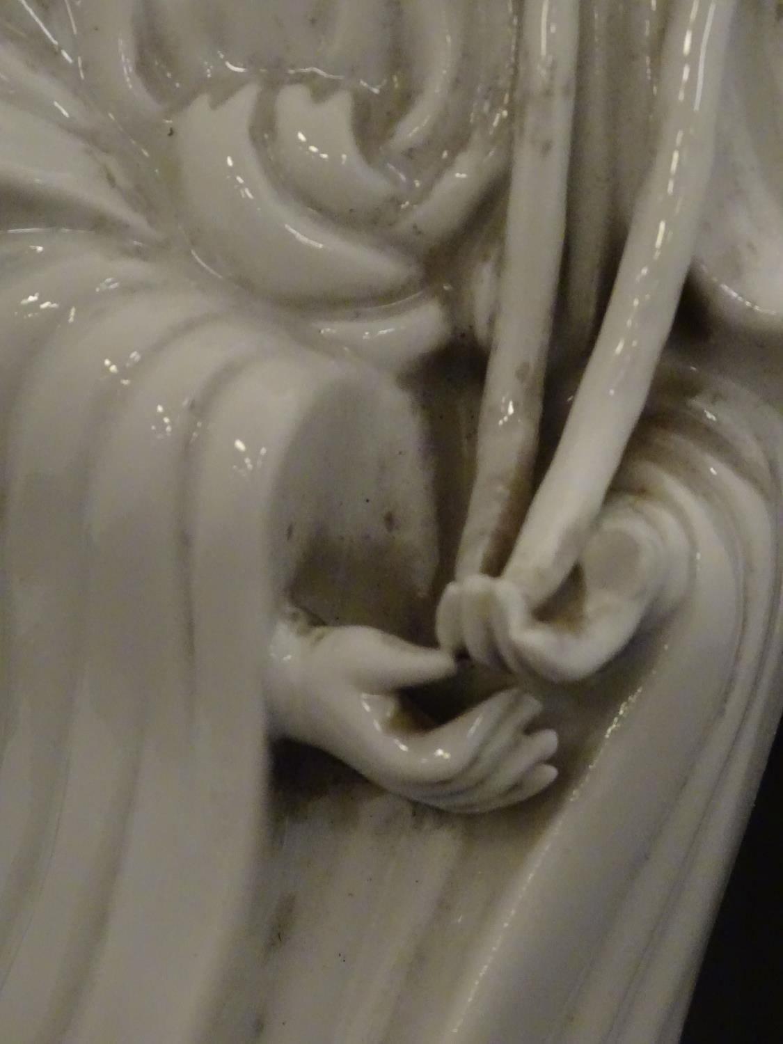 A Chinese blanc de chine figure of Guanyin holding flowers, raised on a base of lotus flowers and - Image 8 of 9