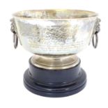 A large pedestal trophy / presentation bowl with hammered decoration, twin lion masks and ring