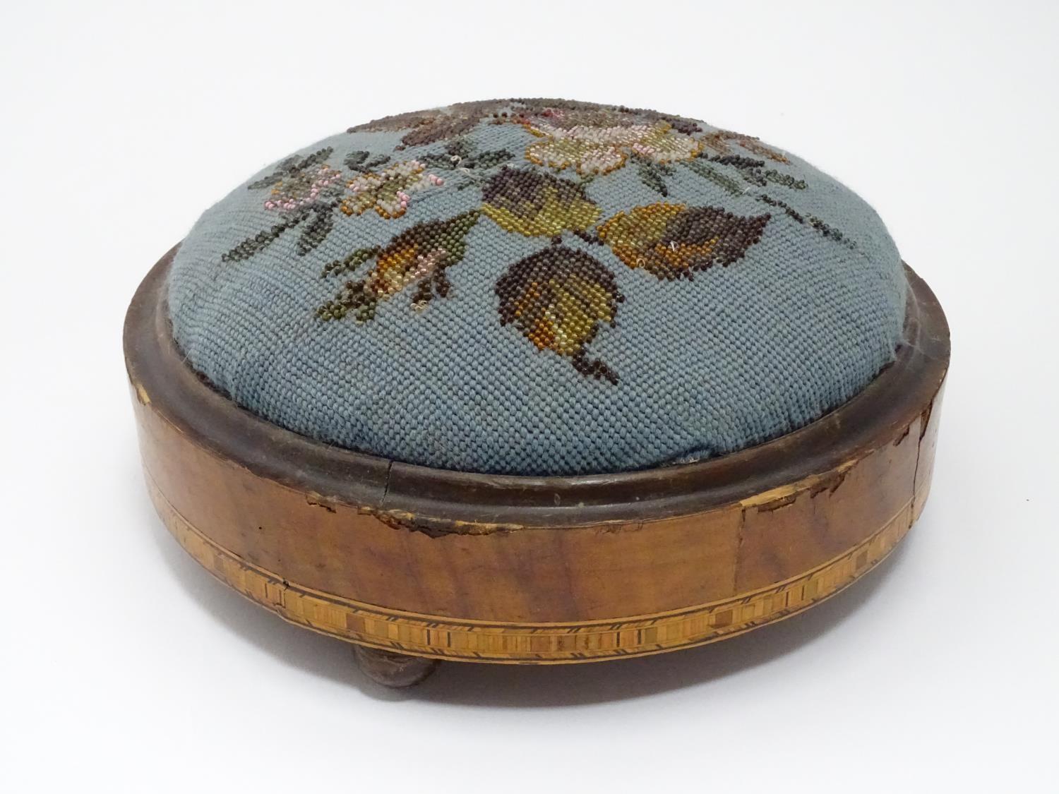 A Victorian walnut footstool of circular form with bead decoration Please Note - we do not make