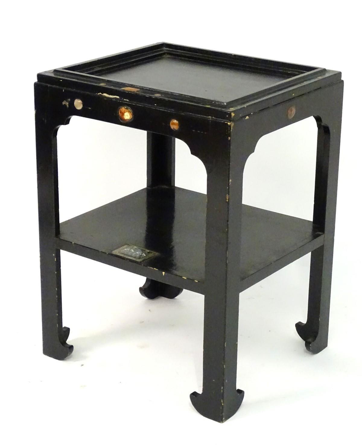 A 20thC ebonised table set with stones and resin gems, the under tier having a decorative