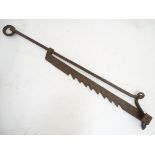 An 18th / 19thC wrought iron pot hanger of adjustable form, extending to a maximum of 51'' Please
