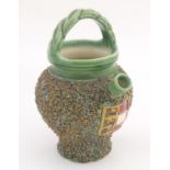 A small jug with a green ground spout and over handle. The textured body decorated with an