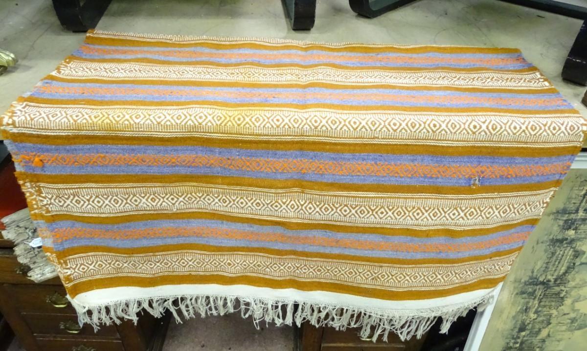 A rug with orange, blue and white ground Please Note - we do not make reference to the condition