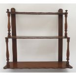 An early 20thC set of mahogany wall shelves with turned supports and three shaped tiers. 27'' wide 6