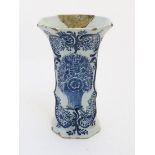 An 18thC Delft blue and white octagonal vase with a flared rim, decorated with a vase of flowers and