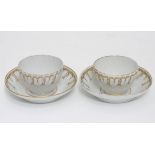 A pair of hand painted coffee cups and saucers Please Note - we do not make reference to the
