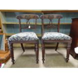A pair of early / mid 19thC mahogany chairs, having a carved top rail and central splat with a