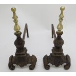 Fire dogs: a pair of 20thC cast iron Andirons / Firedogs, each surmounted by a turned brass baluster