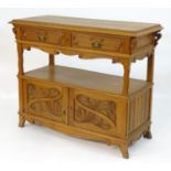 An early 20thC Art Nouveau oak buffet with a moulded top, decorative pierced brackets and a shaped