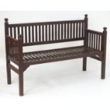 An early 20thC Heals bench of slatted teak construction. 53" long x 21" wide x 36" high. Please Note