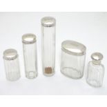 A collection of five silver lidded glass dressing table bottles, all of the silver lids, with the