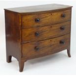 A Regency mahogany chest of drawers with a bow front and reeded edge above three long drawers with