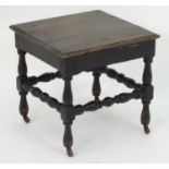 A 19thC oak stool on turned legs united by a box stretcher, the turned feet terminating in porcelain