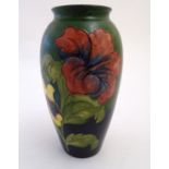 A Moorcroft baluster vase in the hibiscus flower pattern. Impressed and painted marks under. Approx.