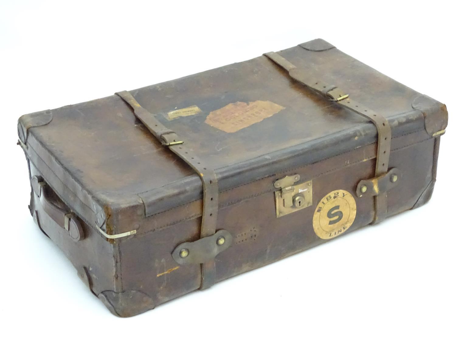 A late 19thC leather travelling trunk flanked by carrying handles. 34" long x 19" wide x 11" high.