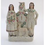 A Victorian Staffordshire flatback figural group depicting a man and woman with a deer flanking a