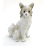 A Nao figurine modelled as a seated long haired chihuahua / papillon dog. Impressed NAO mark to