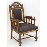 A mid 19thC Gothic armchair with a pierced lancet shaped cresting rail, Gothic tracing above an