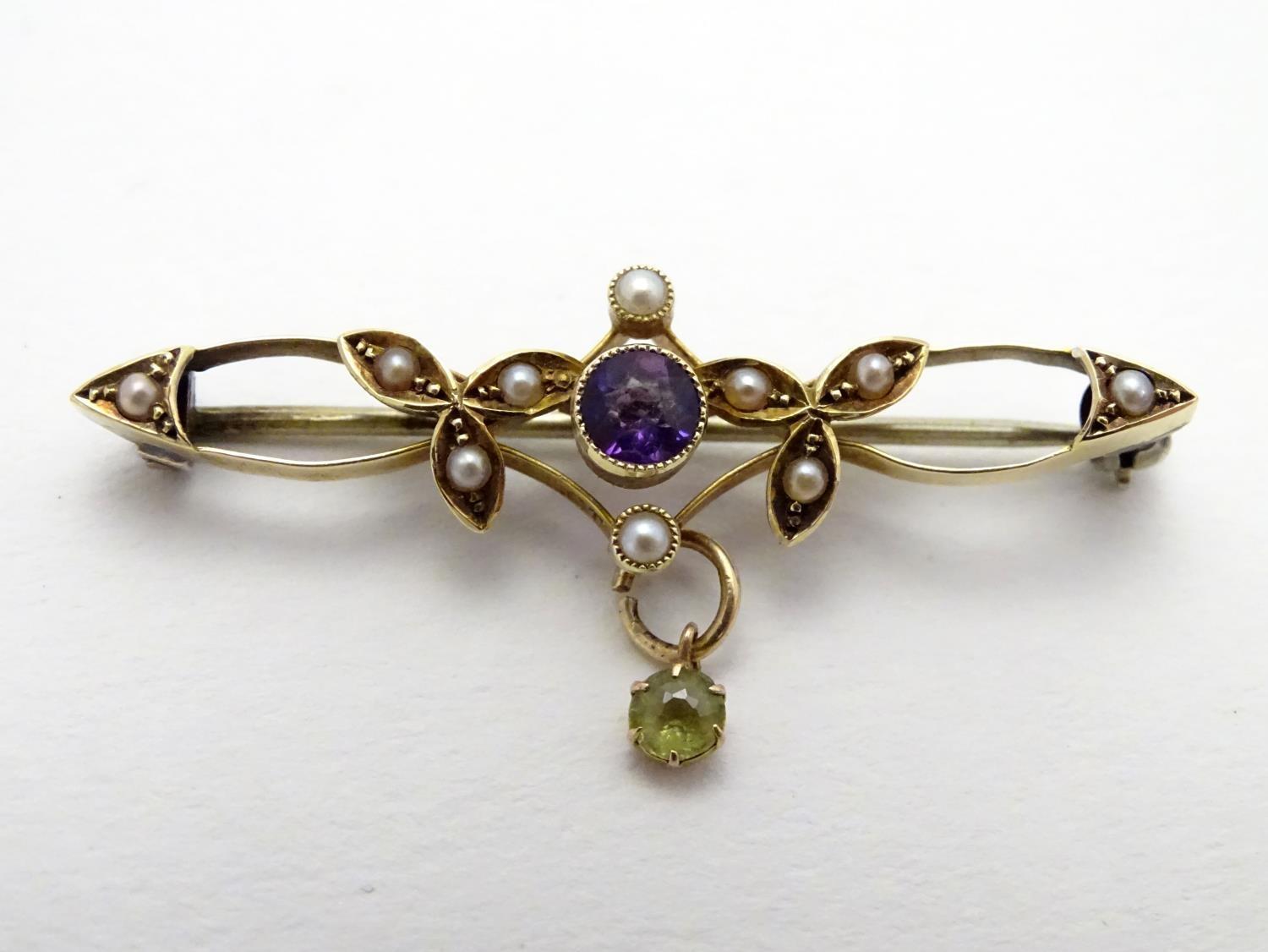 Suffragette jewellery : An early 20thC 15ct gold brooch set with amethyst, seed pearls and peridot (