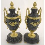 A pair of late 19thC grey marble garnitures of urn form with gilt metal handles and mounts.