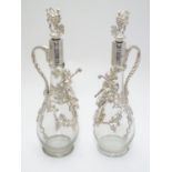 A pair of glass claret jugs / wine ewers with silver plate mounts and stopper. The whole approx. 14"