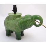 An early 20thC ceramic figural table lamp, formed as an Indian elephant with howdah. Approximately