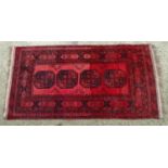 Carpet / Rug : A red ground rug with banded decoration and four central octagonal medallions. Approx