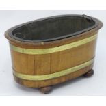 A 19thC mahogany wine cooler / ice bucket with a removable copper liner, lead interior and having
