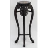 A marble topped jardiniere stand in the Oriental style with floral carved detailing, beaded