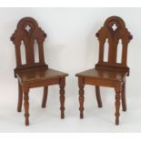 A large Gothic hall chair with pierced quatrefoil decoration and lancet shaped cut outs, standing on