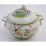 A Chinese tureen and cover with twin handles decorated with a stylised landscape with a tree and