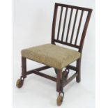 A Georgian mahogany chair raised on large wooden castors with a mechanical action, having a