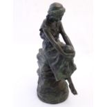 A 20thC bronze statue after Gugliemo Bracony, depicting a young woman seated on rocks. Cast