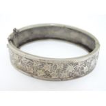 A Silver bracelet of bangle form with engraved decoration Please Note - we do not make reference