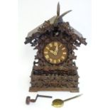 A 19thC Black Forest carved wood cuckoo table clock in the manner of Johann Baptist Beha. The wooden