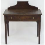 An early 19thC Welsh oak side table with a shaped upstand above a rectangular top and a single