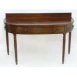 A mid 19thC mahogany serving table, with an up stand above a bowed front with decorative
