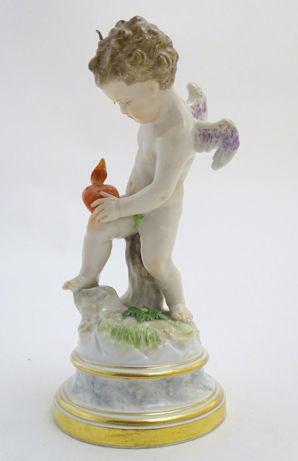 A late 19thC Meissen figure of Cupid holding an arrow and a flaming heart. On a naturalistic base. - Image 3 of 9