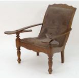 A late 19thC walnut plantation chair with pivoting arm rests, shaped frame and brass studded