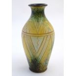 A 20thC studio pottery baluster vase with incised geometric decoration. Impressed G maker's mark