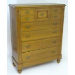 An early 20thC large walnut chest of drawers with a moulded top above a deep central drawer