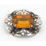 A white metal brooch set with central cirtine coloured stone within an acanthus mount. 1 1/4" wide