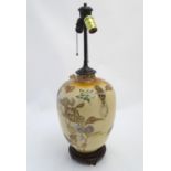 An Oriental ceramic urn table lamp, the body decorated with floral detail, twin light fittings and