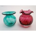 A cranberry Dartington Crystal pot, with lobed exterior, together with a green Hillrace Glass pot,